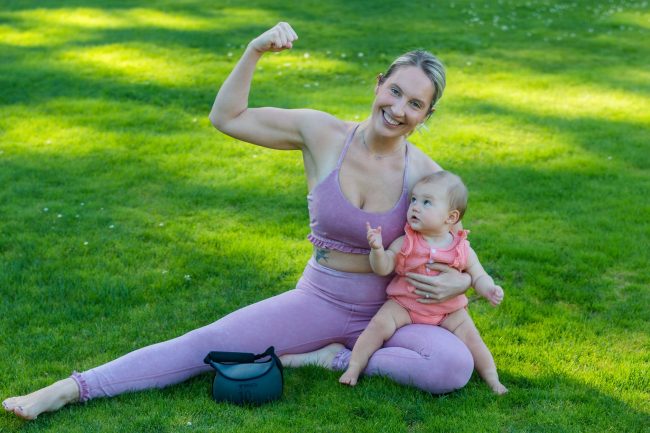 pexels-photo-9472308 woman in pink tank top carrying baby on her lap