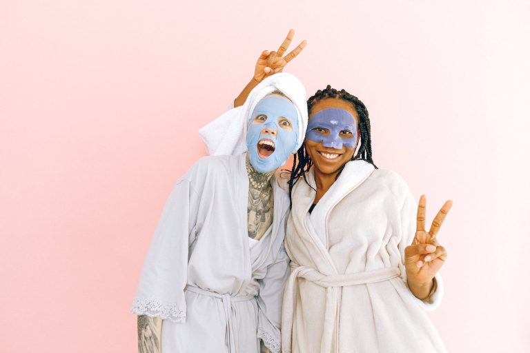 happy multiethnic female friends in sheet masks showing peace gesture