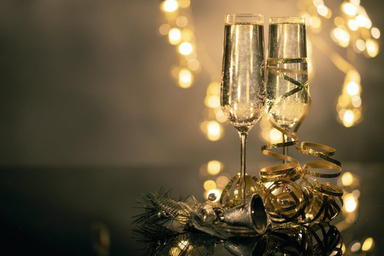 pexels-photo-3036525 close up of two flute glasses filled with sparkling wine wuth ribbons and christmas decor