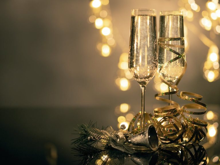 pexels-photo-3036525 close up of two flute glasses filled with sparkling wine wuth ribbons and christmas decor