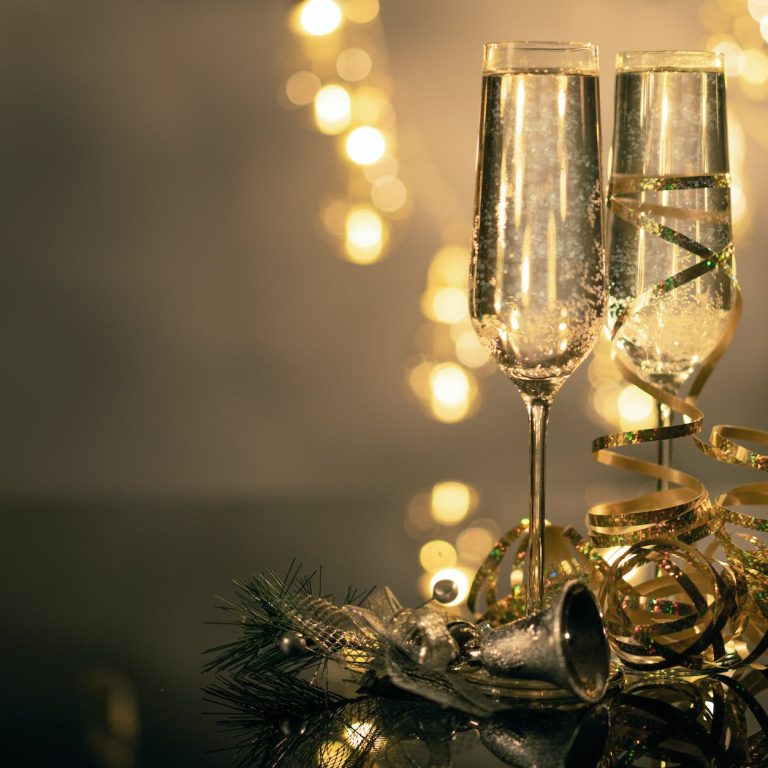 pexels-photo-3036525 close up of two flute glasses filled with sparkling wine wuth ribbons and christmas decor