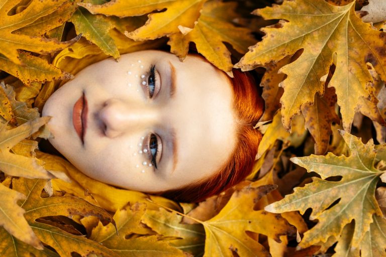 pexels-photo-19302427 redhead model face among autumn leaves