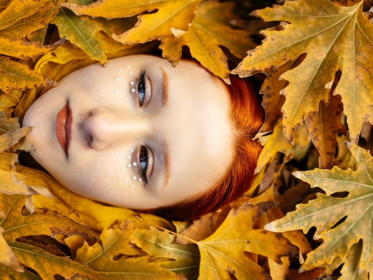 pexels-photo-19302427 redhead model face among autumn leaves