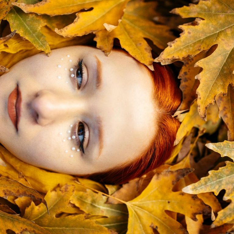 pexels-photo-19302427 redhead model face among autumn leaves
